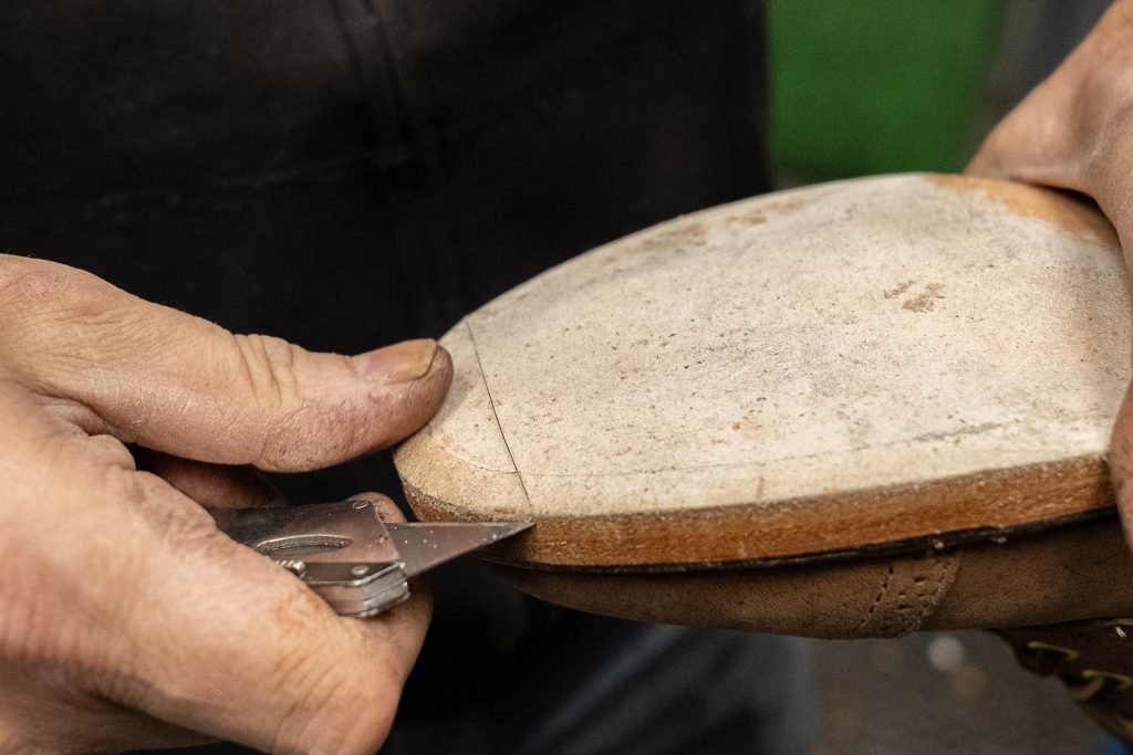 making an incision on the leather sole