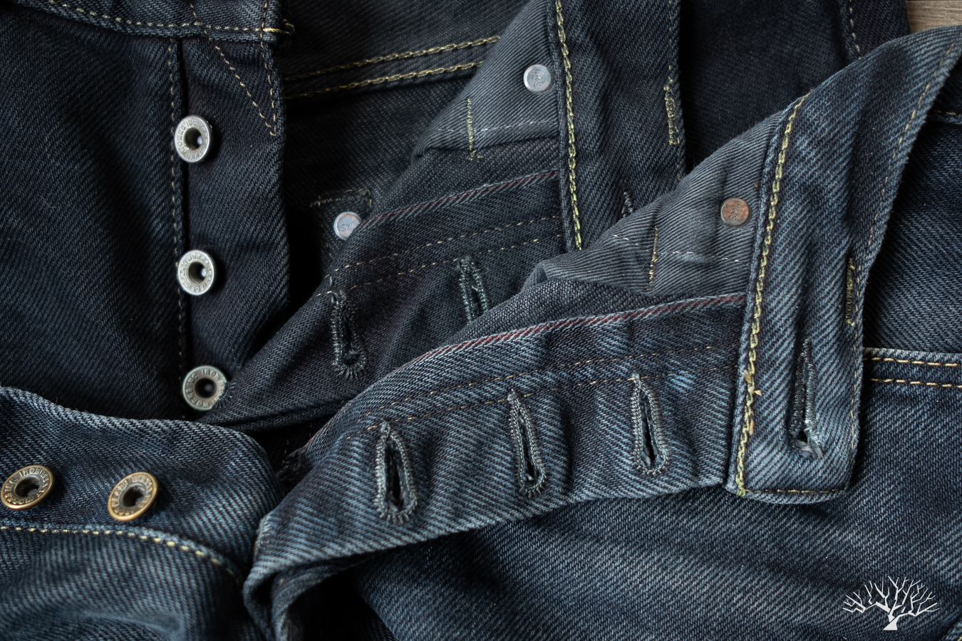 Iron Heart 21oz overdyed black selvedge denim pair compared to a brand new pair, inside the button fly selvedge ticker